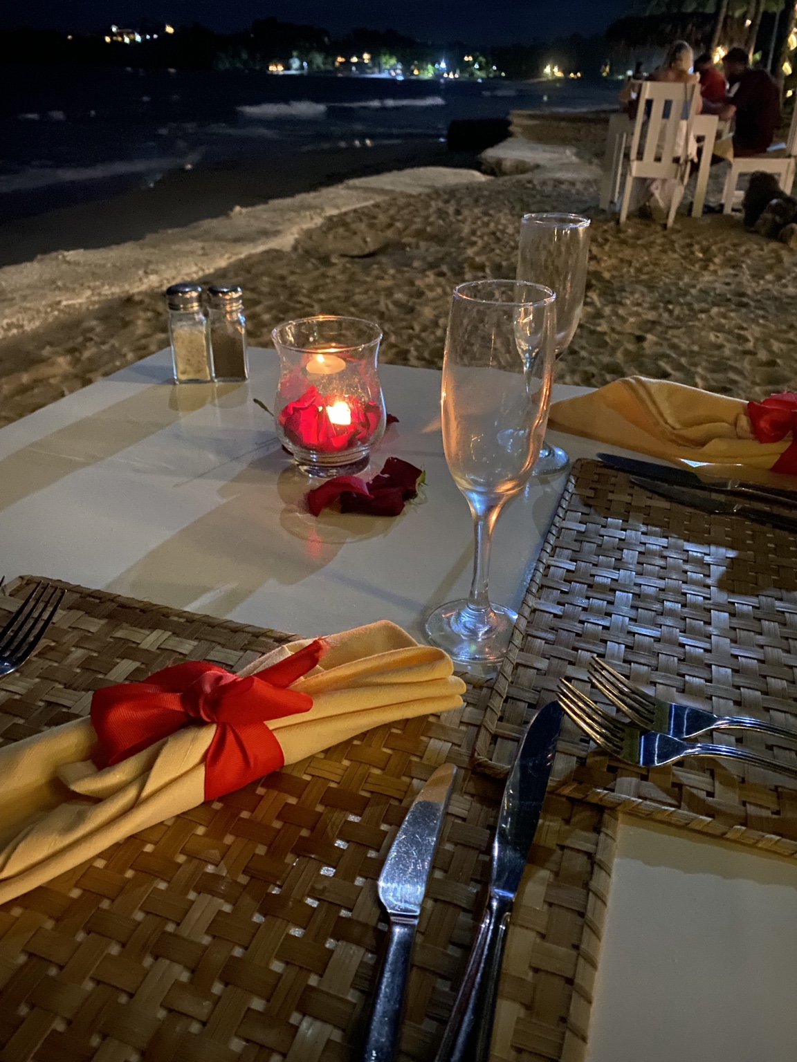 Candlelit dinner table prepared beside the beach